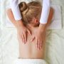 Masseur doing back massage to child.
