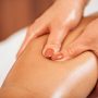 Lymphatic drainage massage. Hands of a masseuse massaging leg of a female client
